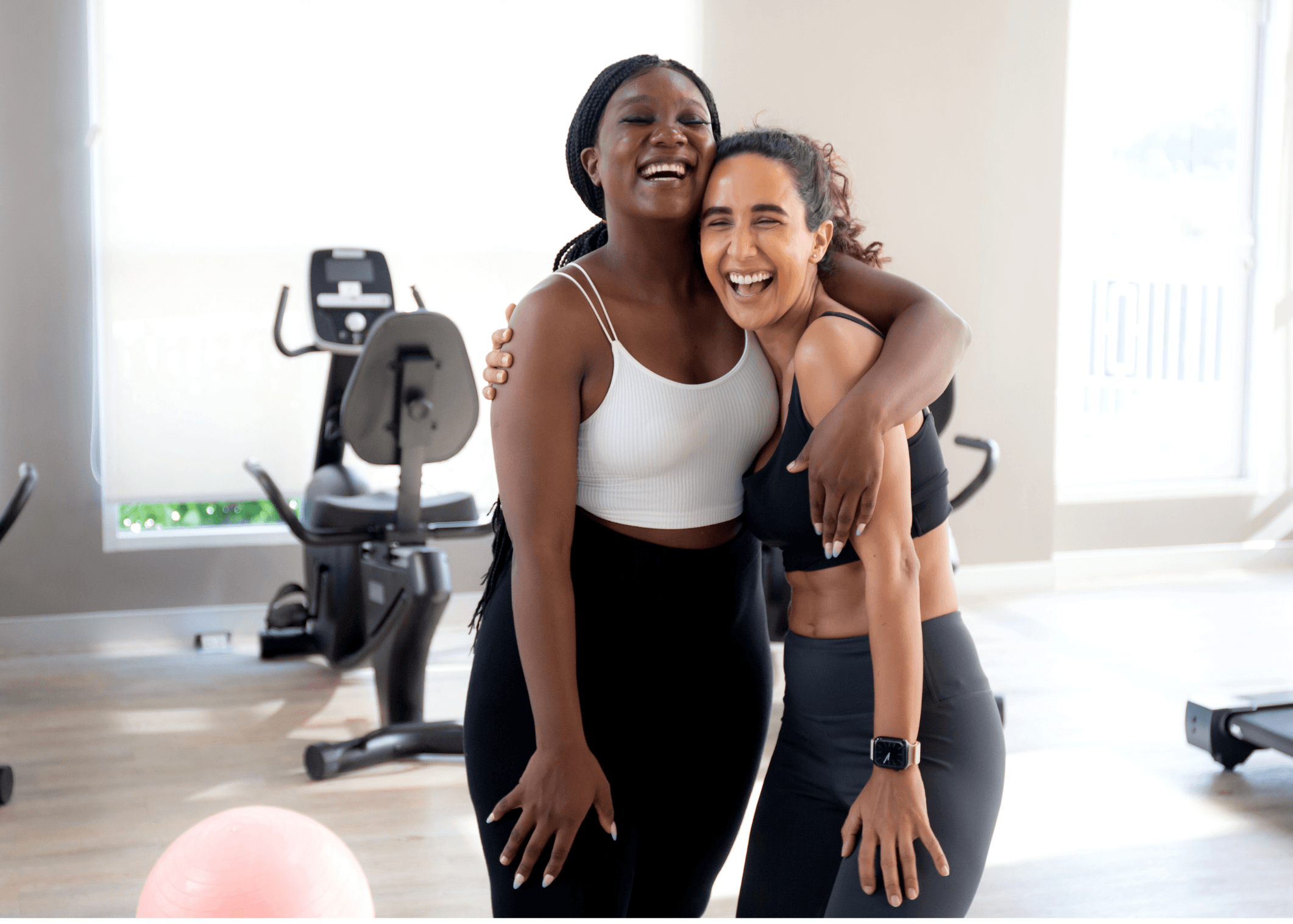 Two women laughing together after a workout